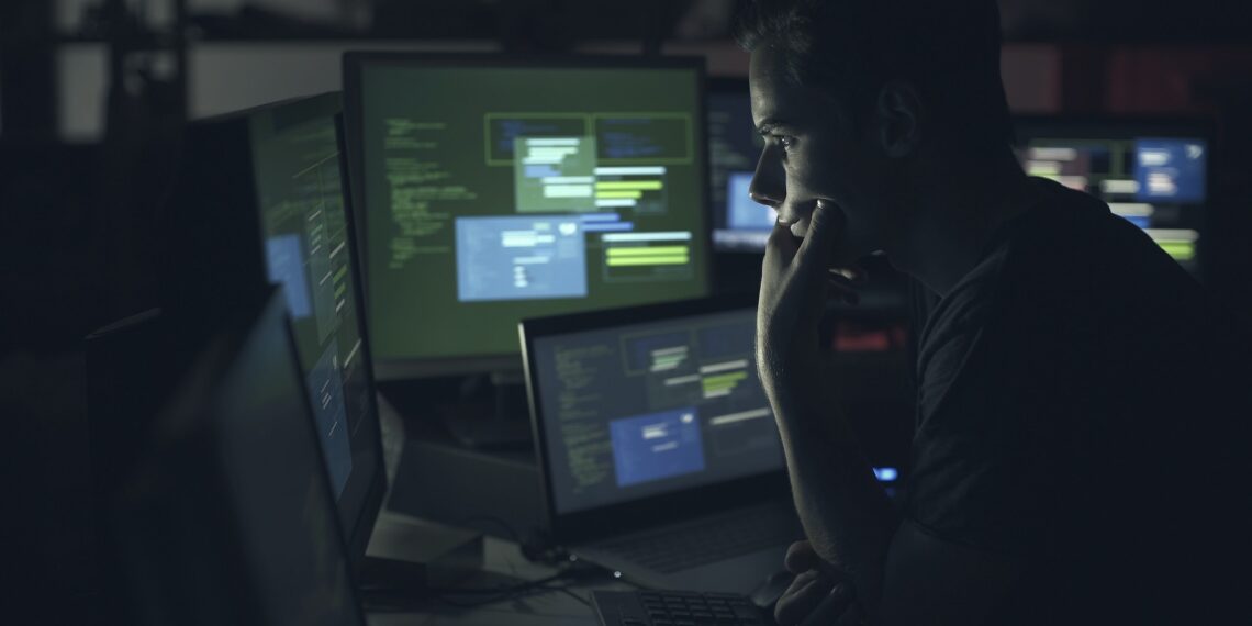Computer developer working with computers at night