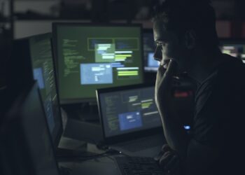 Computer developer working with computers at night