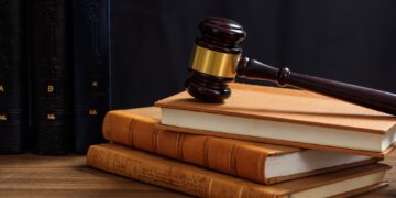 Judge gavel on law books, wooden desk