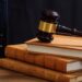 Judge gavel on law books, wooden desk