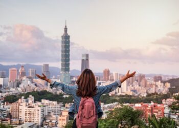 Young woman traveler looking beautiful cityscape at sunset in Taipei, Travel lifestyle concept